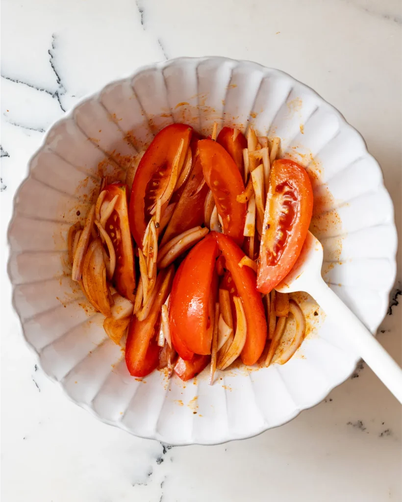 Marinate the tomatoes in harissa dressing