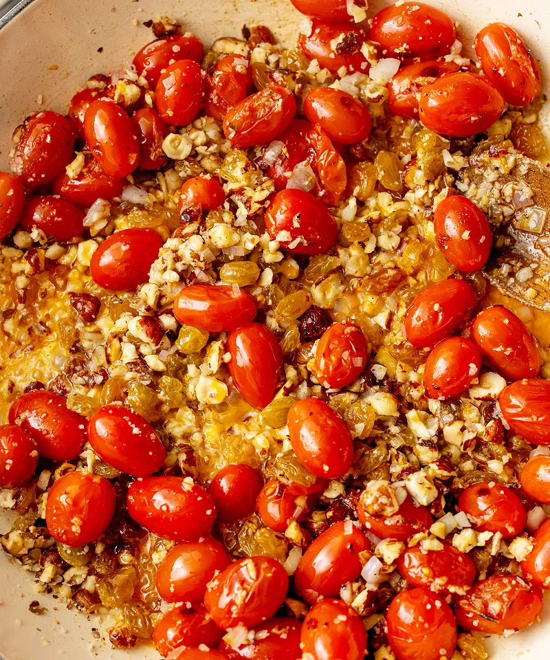 Saute tomatoes with hazelnuts and raisins