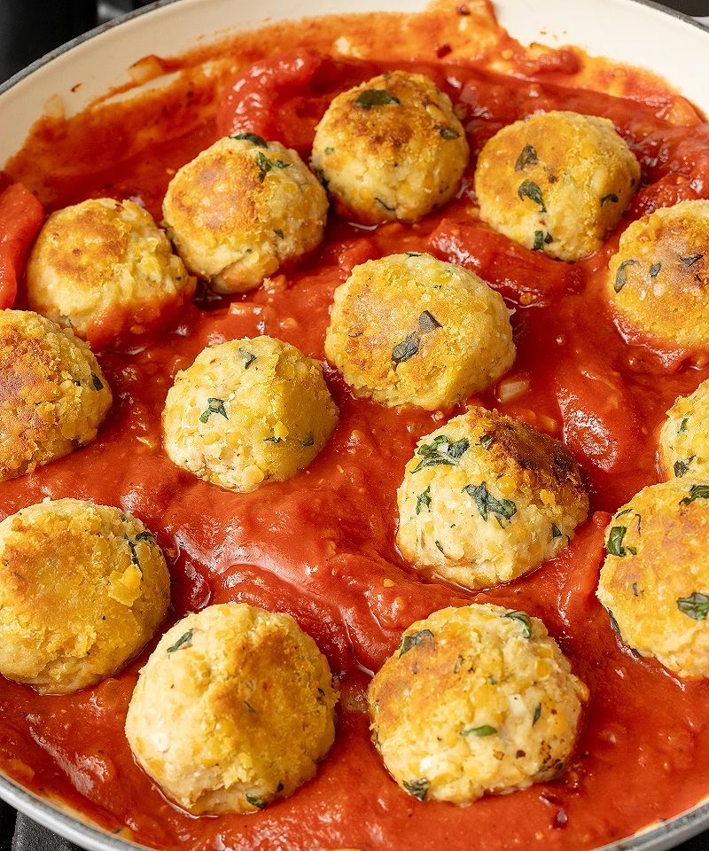 Simmer red lentil balls in red sauce